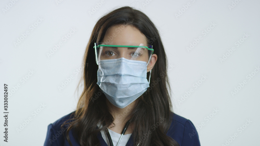 Closeup of bruentte nurse wearing protective goggles and mask Closeup of bruentte nurse wearing protective goggles and mask