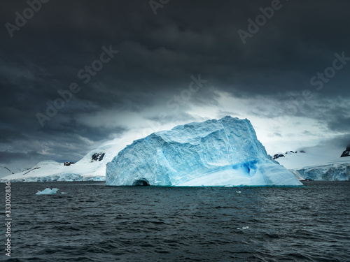 mountain-shape huge iceberg under dramatic sky in Antarctica