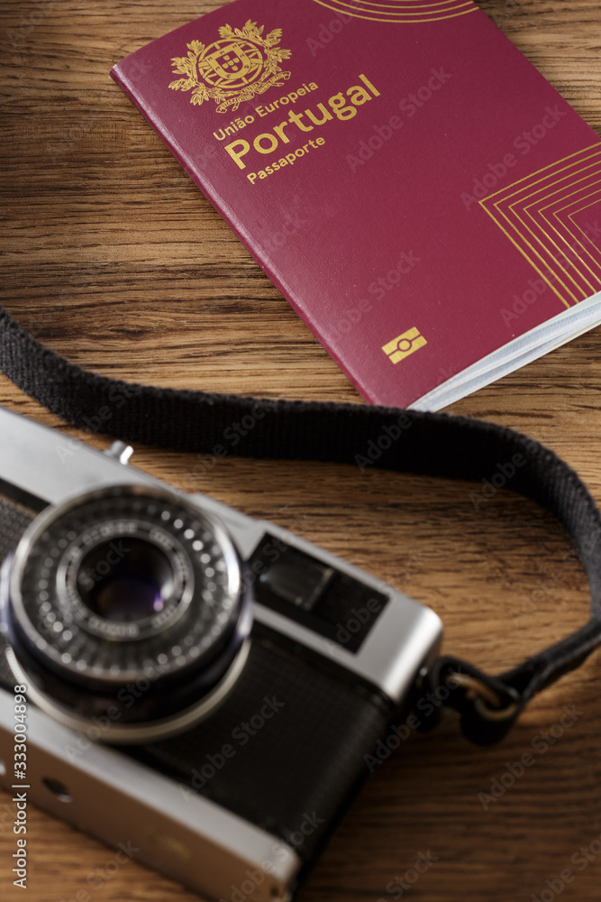 Camera e passaporte sobre mesa de madeira