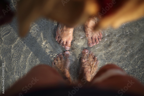 The feet of two people who soak in the beach