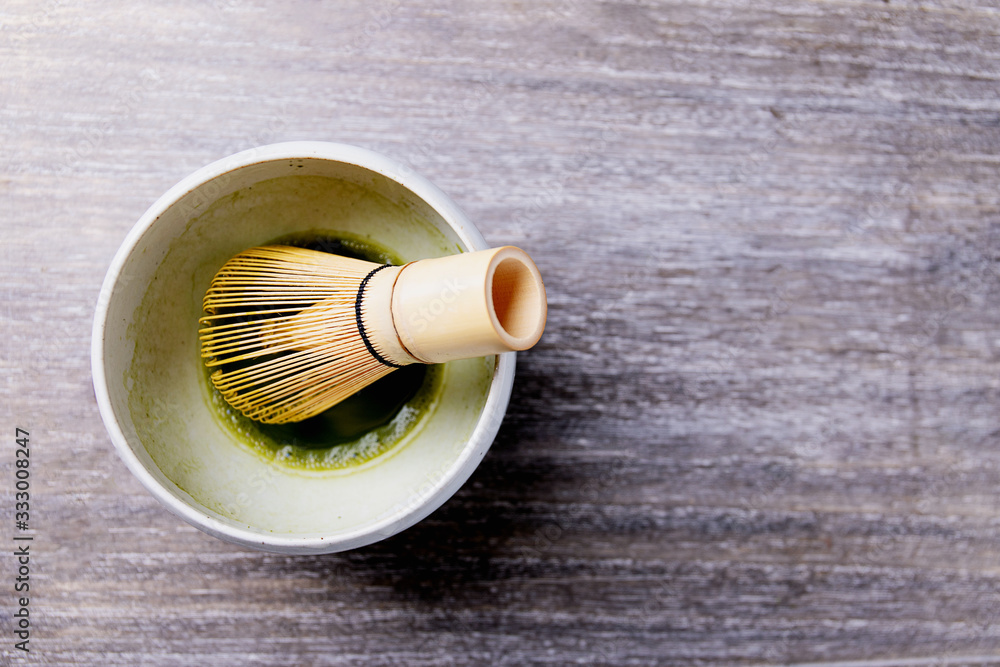 Peparation of Matcha tea: bamboo matcha whisk in a ceramic bowl witrh matcha tea. Top View. Copy Space Peparation of Matcha tea: bamboo matcha whisk in a ceramic bowl witrh matcha tea. Top View. Copy Space