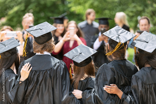 Group of graduate friends pose for parents photo