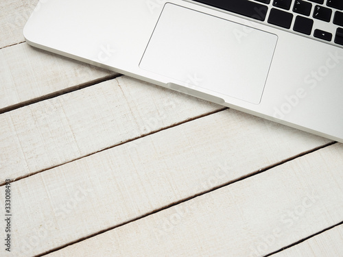 Workplace - laptop for remote work on a white wooden table. Freelance desktop for home or office. Background with copy space.