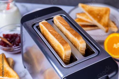 Slices of toast coming out of the toaster for healthy breakfast photo