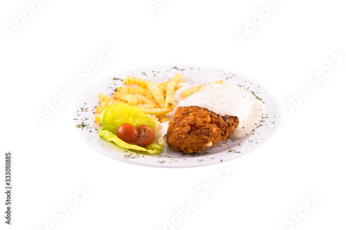 Breaded chicken in a creamy sauce with french fries. Photo taken on a white background. Dish of Montenegrin cuisine. Suitable for the restaurant menu.