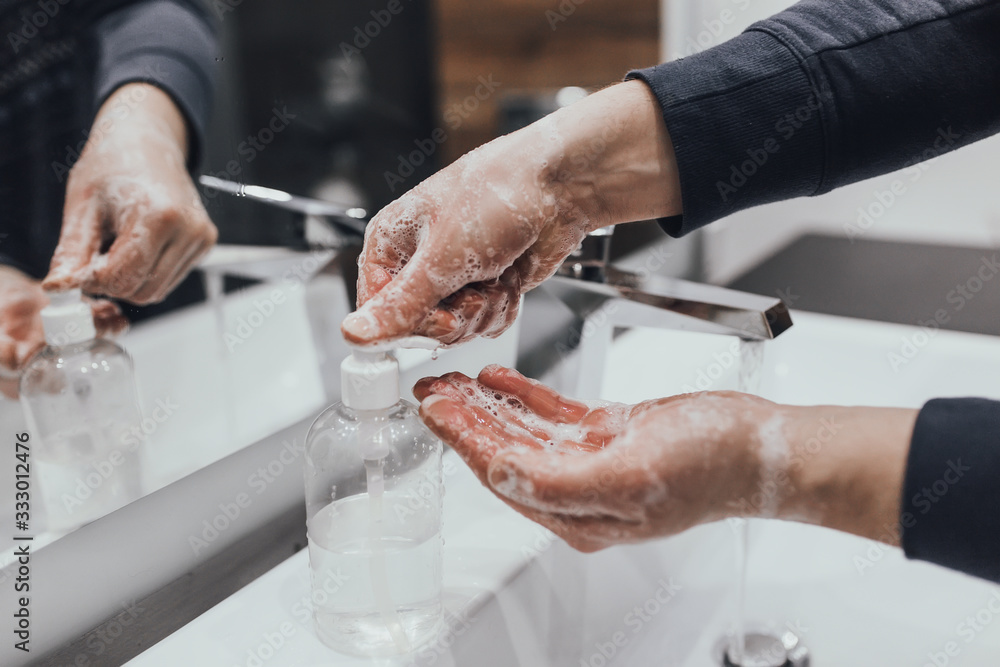 Washing hands with antibacterial soap at home bathroom for coronavirus prevention. Coronavirus pandemic protection by washing hands frequently. Hygiene to stop spreading coronavirus. Washing hands with antibacterial soap at home bathroom for coronavirus prevention. Coronavirus pandemic protection by washing hands frequently. Hygiene to stop spreading coronavirus.