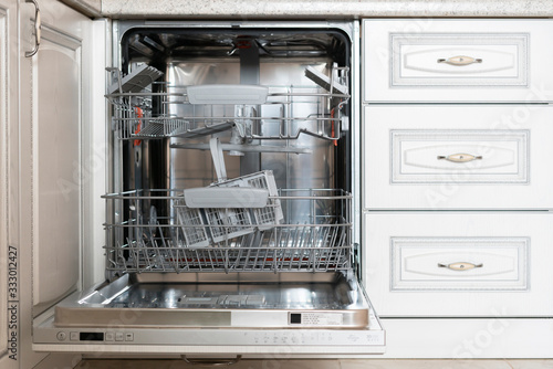 opened new empty dishwasher machine in the kitchen