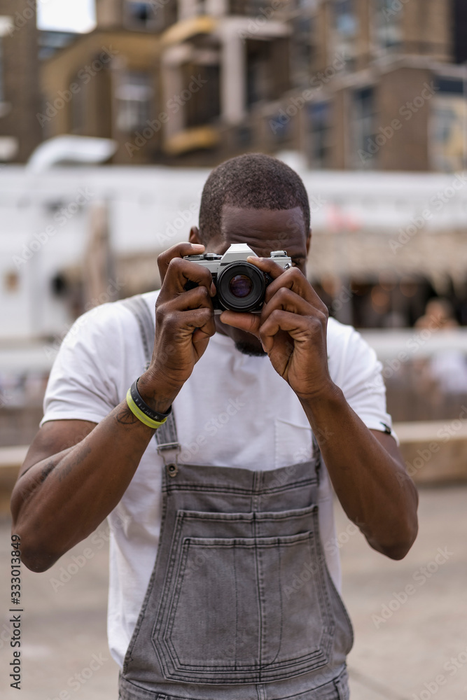 Man taking pictures outdoor in urban area with a vintage camera. Man taking pictures outdoor in urban area with a vintage camera.