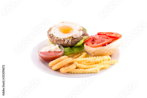 Burger with beef cutlet, egg and tomatoes. Served on a white plate. Photo taken on a white background. Dish of Montenegrin cuisine. Suitable for the restaurant menu.