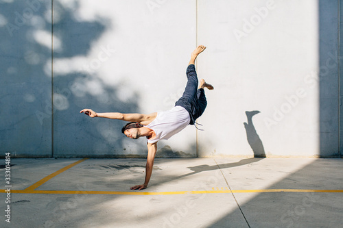 A dancer dancing in front of a concrete wall