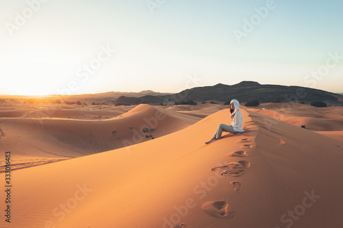 A European woman in a desert wearing white beduin hat photo