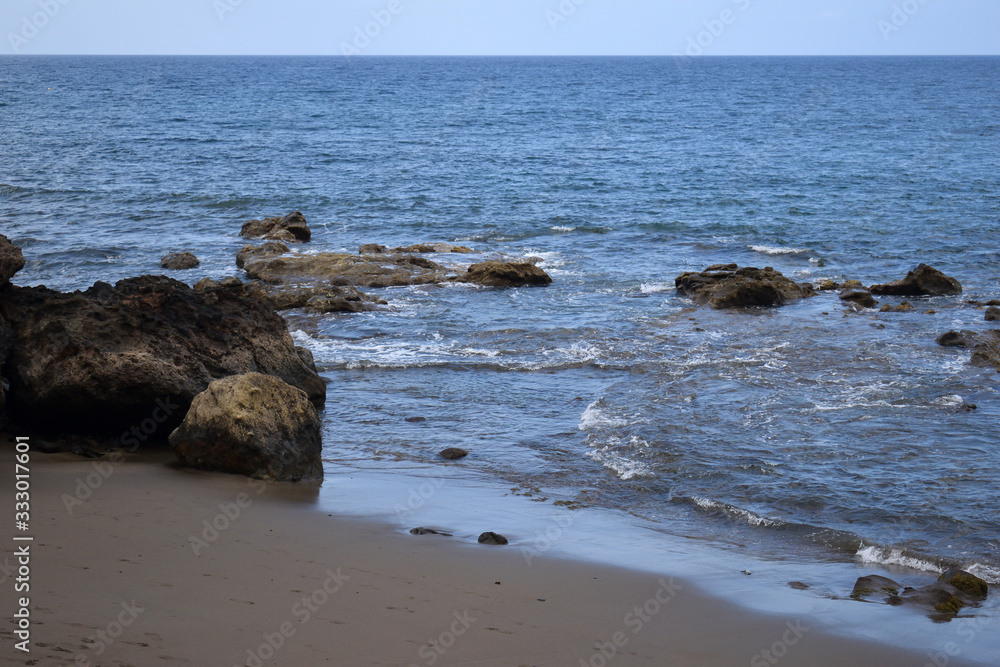 Waves Lapping Sandy Beach with Rocks in Gran Canaria Waves Lapping Sandy Beach with Rocks in Gran Canaria