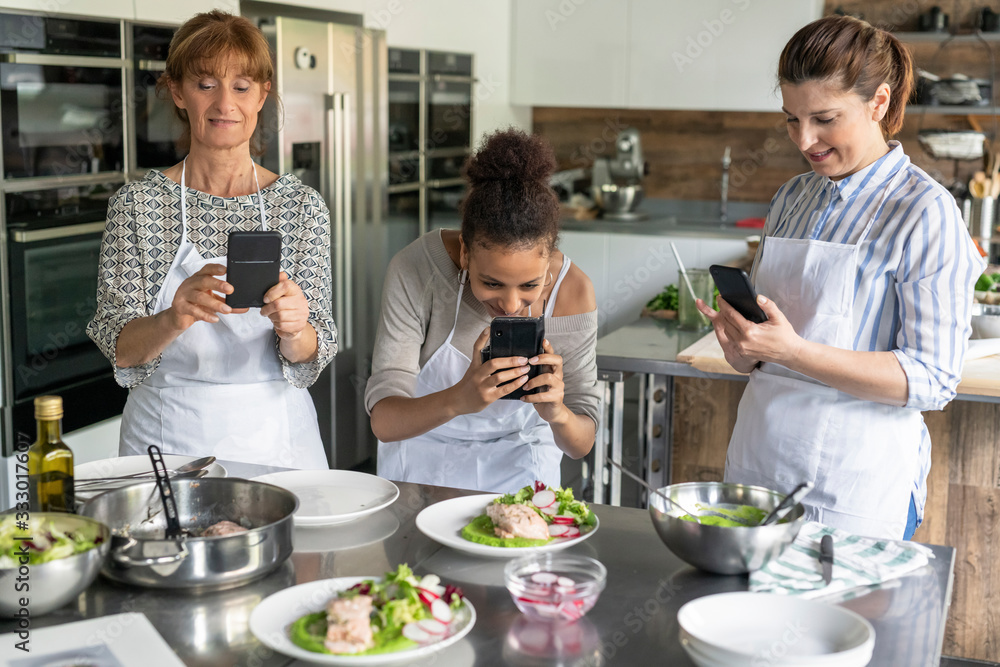 Women taking pictures at the food in kitchen class Women taking pictures at the food in kitchen class