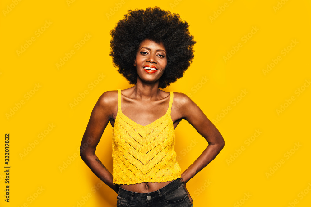 Happy Afro Woman posing over yellow background Happy Afro Woman posing over yellow background