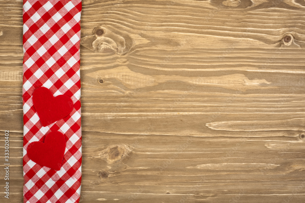 Obraz premium Red checkered tablecloth and wooden spoon for cooking and baking. Background with copy space. Horizontal.