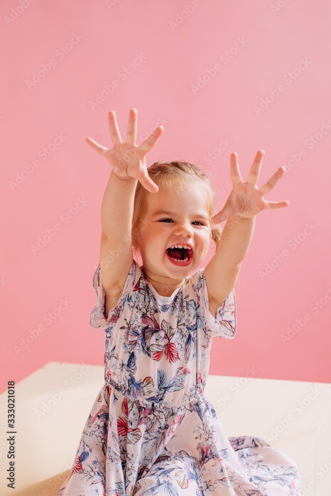 Funny little girl studio portrait on pink background Funny little girl studio portrait on pink background