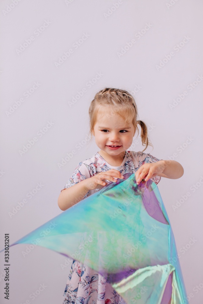 Little girl playing with holographic foil Little girl playing with holographic foil