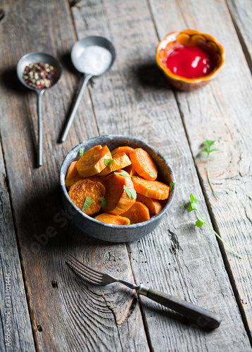Delicious fried sweet potatoes on the wooden background.