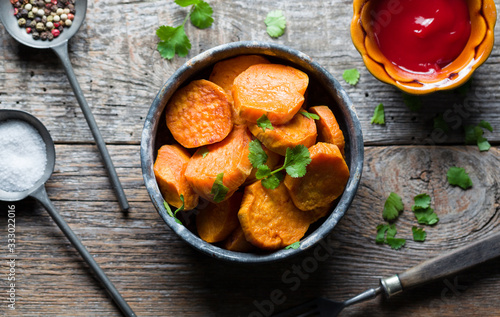 Delicious fried sweet potatoes on the wooden background.