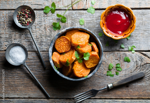 Delicious fried sweet potatoes on the wooden background.