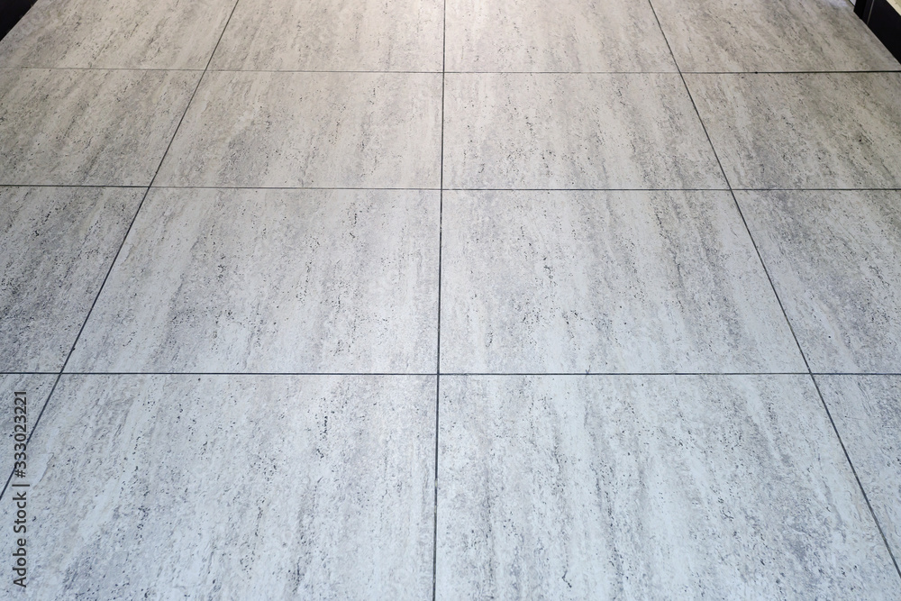 Grey tiled floor in a clean condition with grid lines for the background.