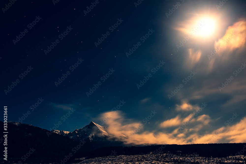Night time landscape view of mountain peak Krivan with moonlight and clouds, High Tatras, Slovakia