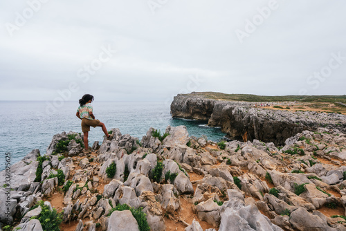 Unrecognizable woman on top of a cliff in Bufones de Pria, Asturias. photo