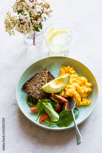 Weekend Brunch with creamy scrambled eggs, toast, avocado, spina photo