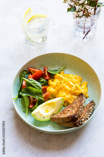 Weekend Brunch with creamy scrambled eggs, toast, avocado, spinach photo