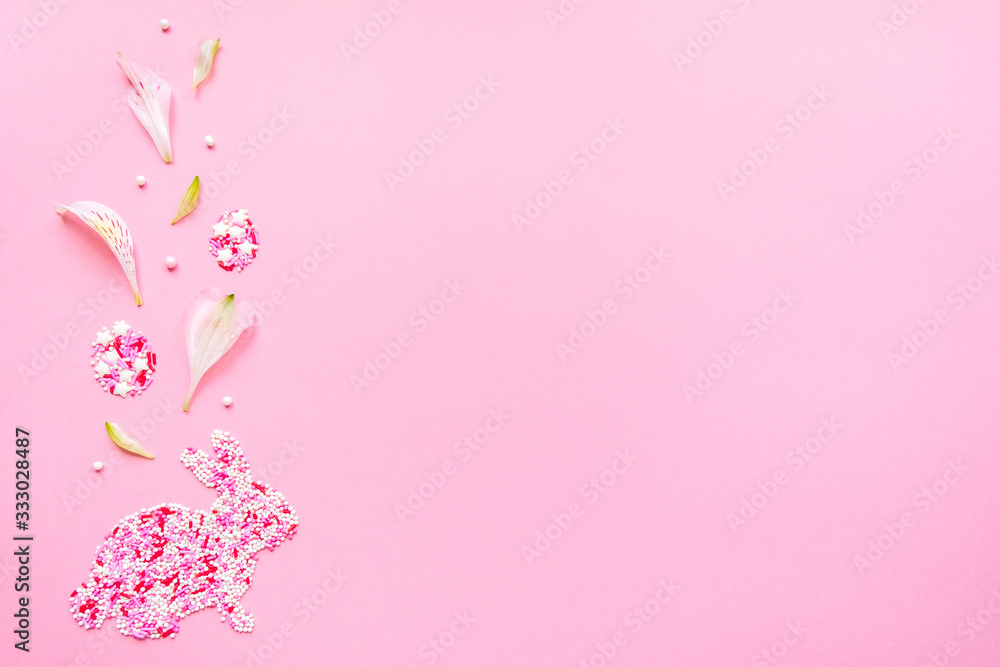 Easter funny bunny from topping. Decorative eggs with flower petals. Flat lay on a pink background Easter funny bunny from topping. Decorative eggs with flower petals. Flat lay on a pink background