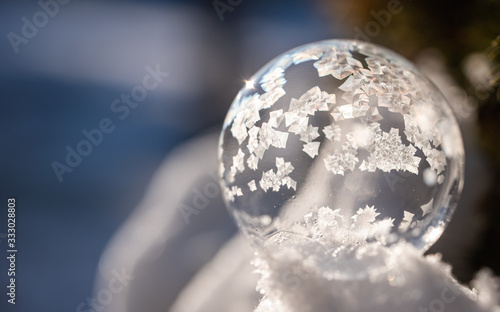 Close up image of soap bubble freezing in the snow on a winter's day. photo