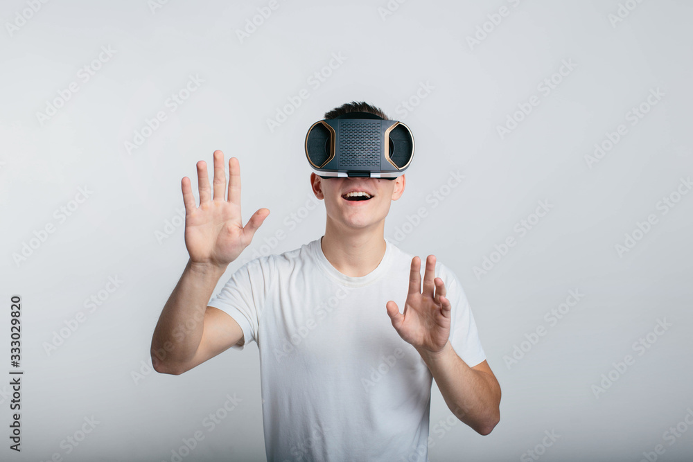 Man wearing virtual reality goggles. Studio shot, gray backgroun Man wearing virtual reality goggles. Studio shot, gray backgroun