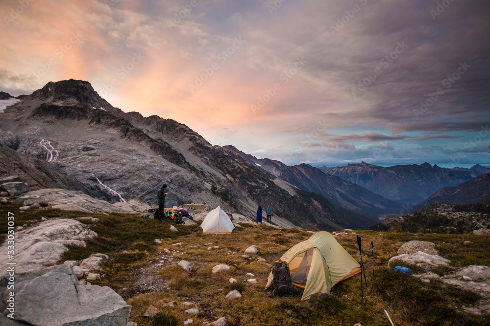 Climbers camping in alpine meadow below mountain Climbers camping in alpine meadow below mountain