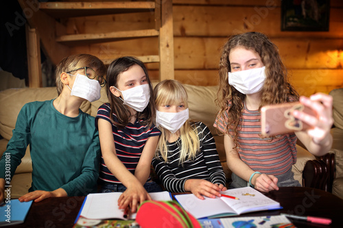 children take pictures wearing masks locked in their homes by a coronavirus pandemic photo