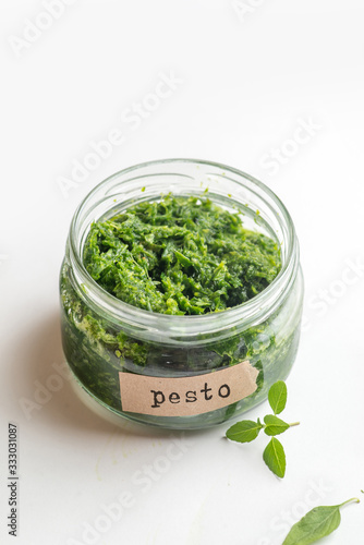 pesto sauce in a jar with a signed label on a white background