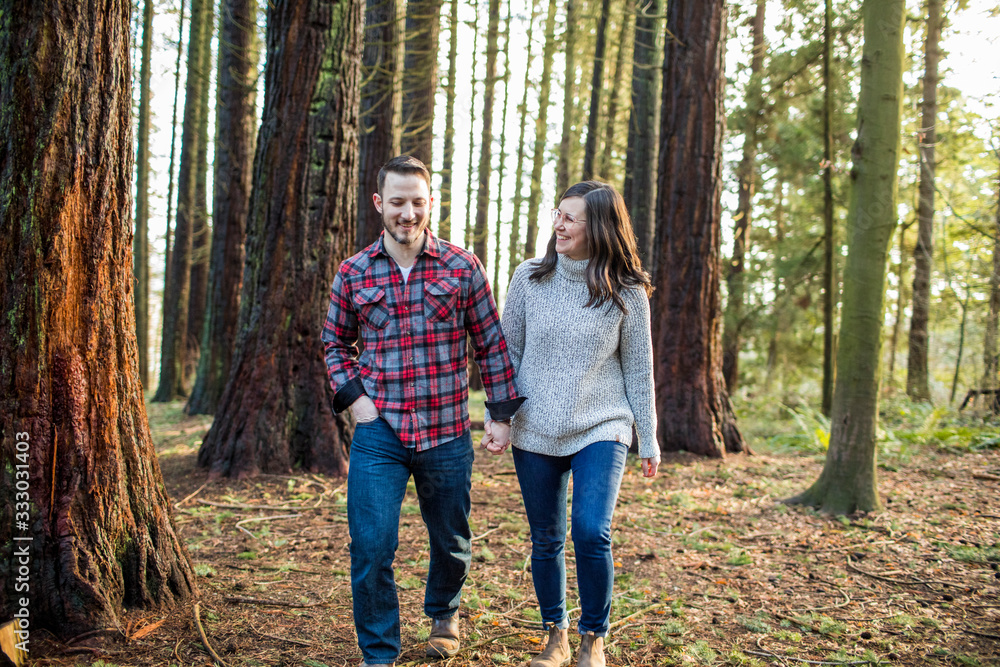 © Cavan Images - Relaxed couple walking through forest in evening light. © Cavan Images - Relaxed couple walking through forest in evening light.