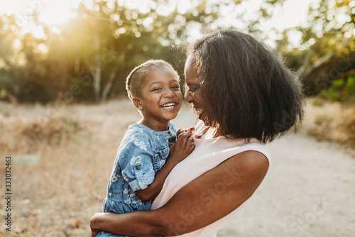 Close up of happy grandmother holding smiling granddaughter outside