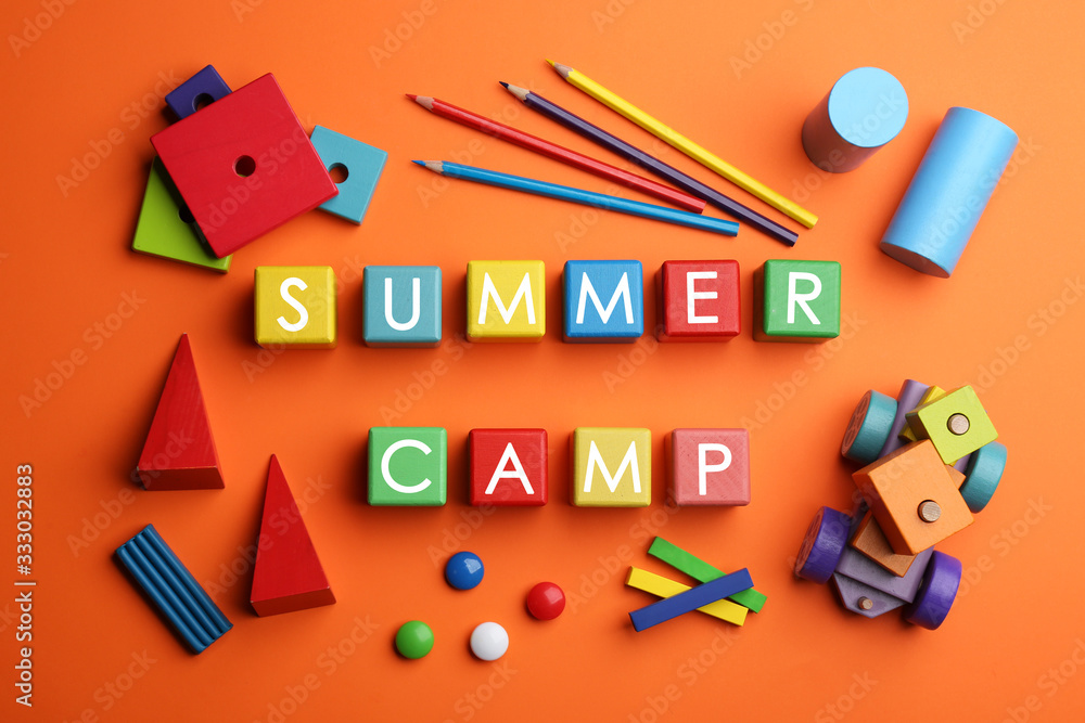 Colorful wooden cubes with phrase SUMMER CAMP on orange background, flat lay Colorful wooden cubes with phrase SUMMER CAMP on orange background, flat lay