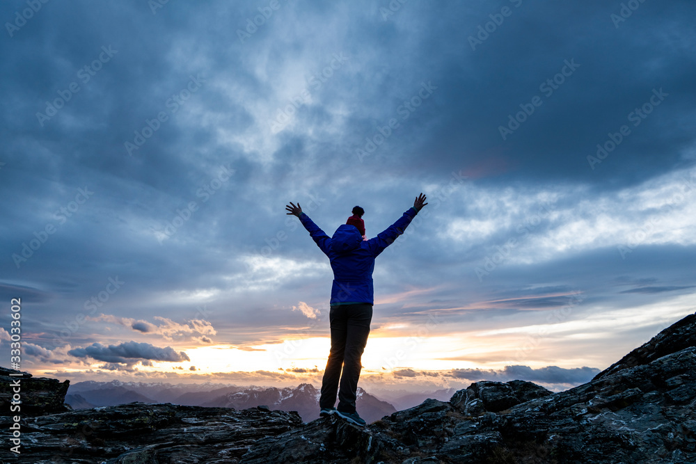 Figure at sunset overlooking the mountains, Southern Alps New Zeala Figure at sunset overlooking the mountains, Southern Alps New Zeala