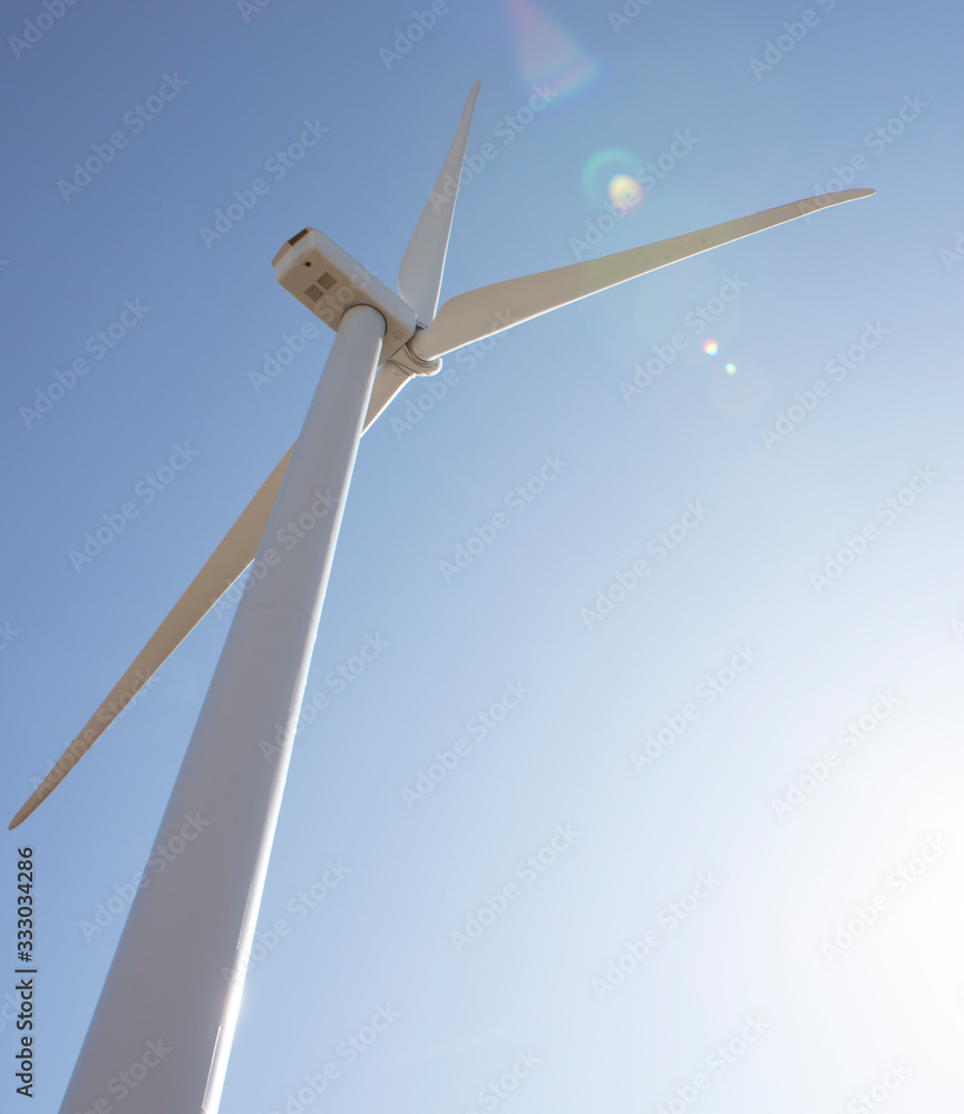 Wind Turbine against blue sky with sun flare Wind Turbine against blue sky with sun flare