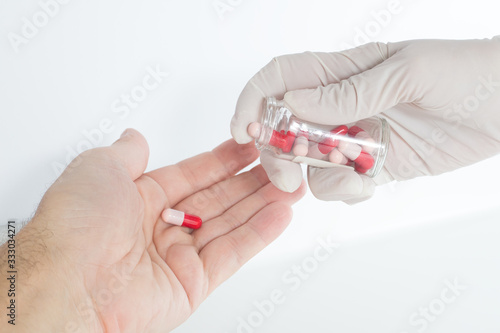 The nurse administers the antibiotic capsule to the patient