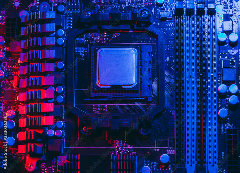 Fototapeta premium Hardware technology concept in neon light. Motherboard in blue-red light. Computer accessories. Dark photo..