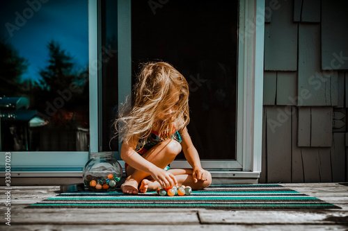 Girl playing with rubber balls outside house photo