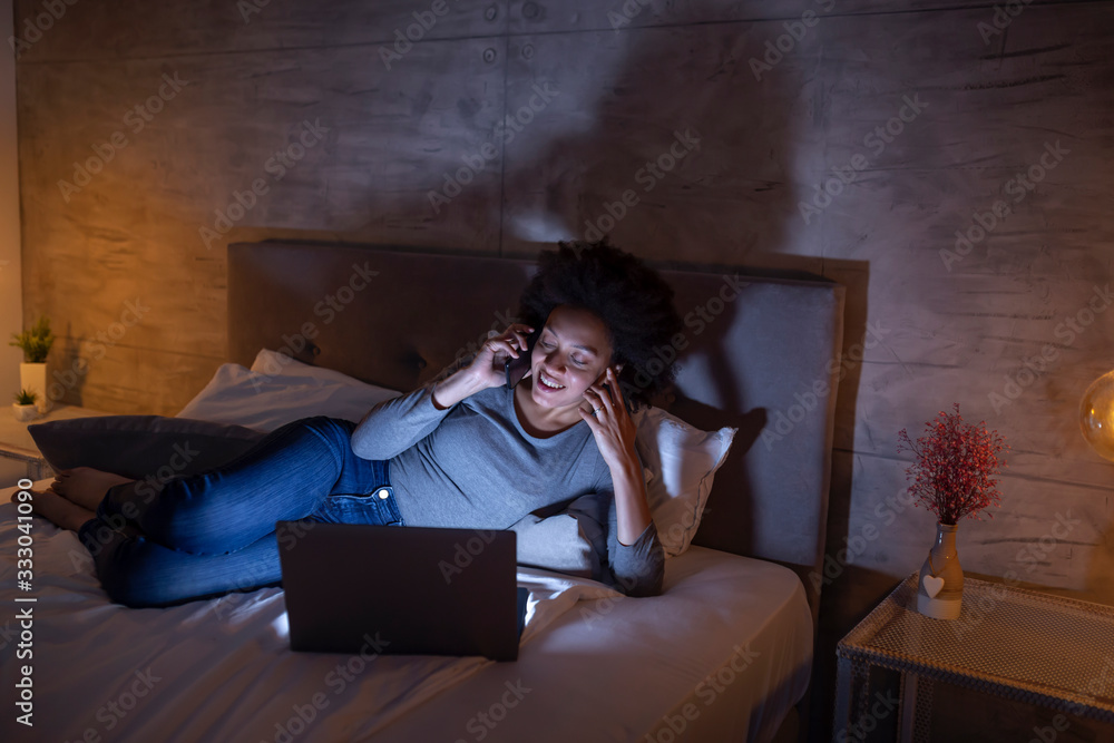 Woman lying in bed having a phone conversation Woman lying in bed having a phone conversation