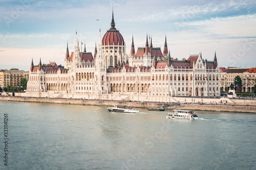 The Budapest Parliament at sunset. Boats passing by on Danube river, Hungary 2019