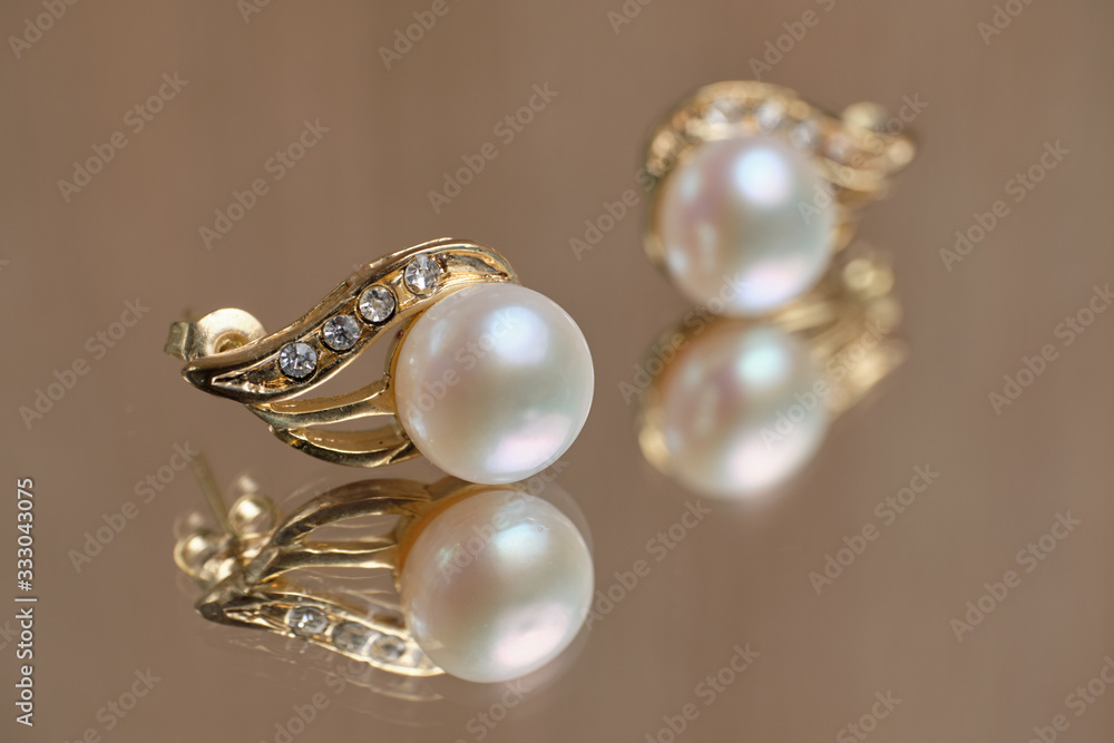 Pearl earrings on a glass table. Pearl earrings on a glass table.