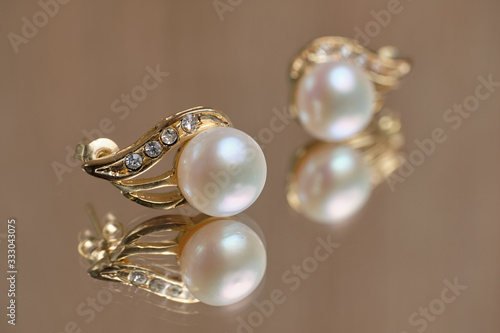 Pearl earrings on a glass table.