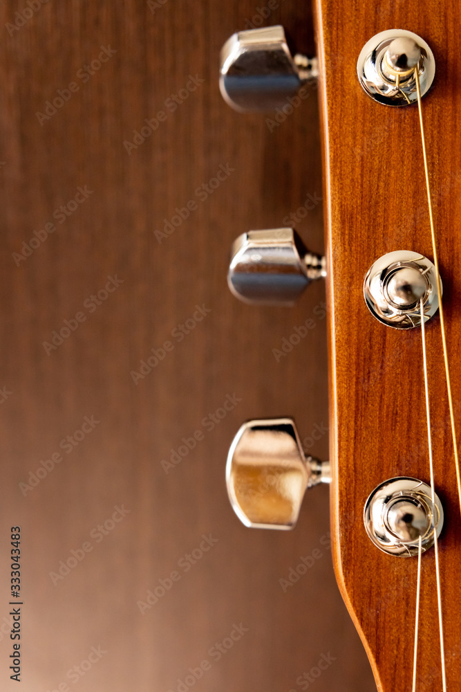 Acoustic guitar neck on a wooden background. Pin mechanism. Backgrounds and textures Acoustic guitar neck on a wooden background. Pin mechanism. Backgrounds and textures