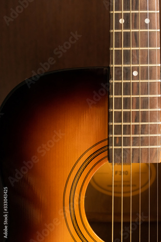 Sound hole of an acoustic guitar, neck, strings, frets, the nut.