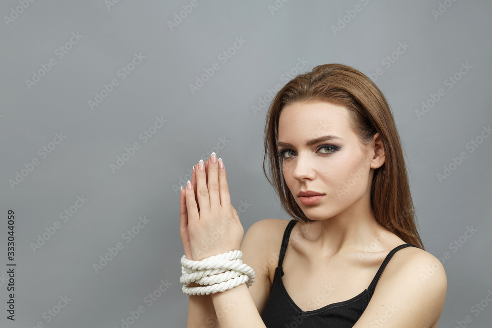 Beautiful girl with tied hands with a rope Beautiful girl with tied hands with a rope
